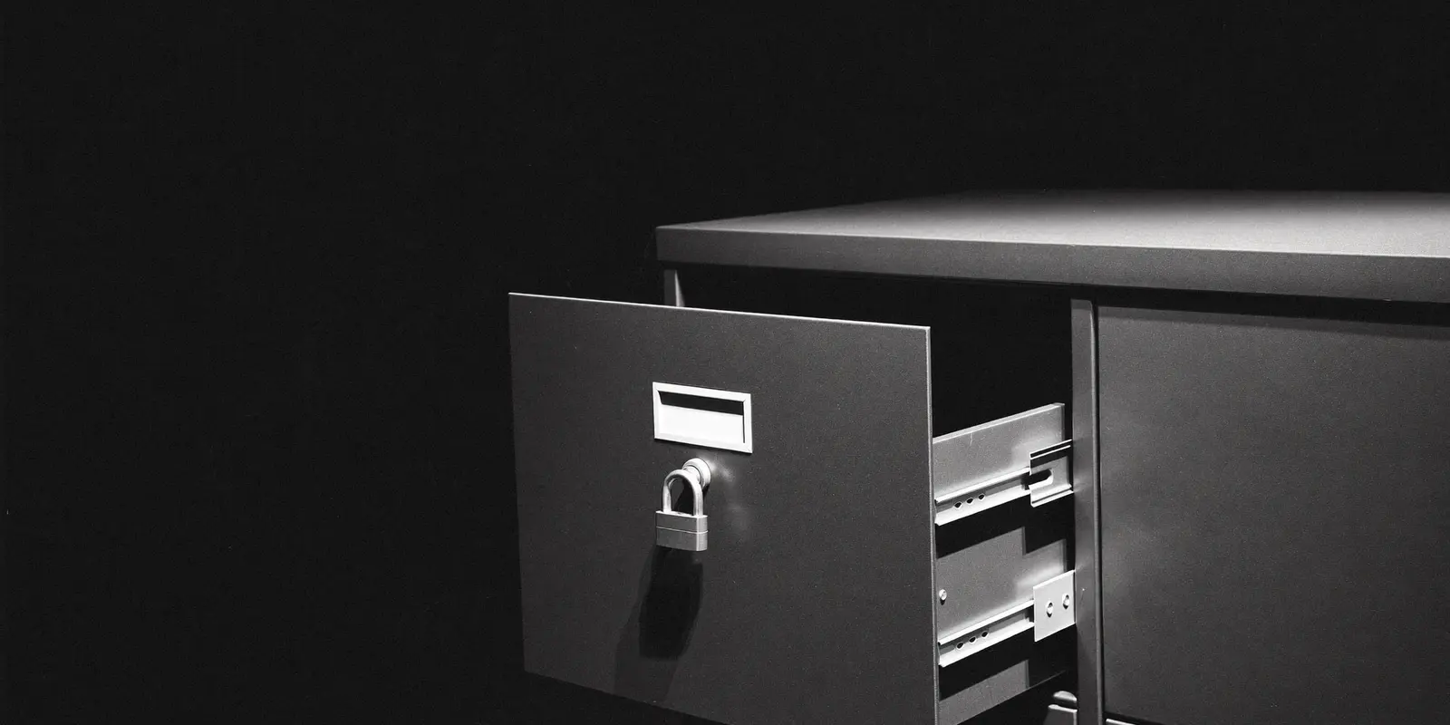 A partly open metal filing cabinet drawer with a lock, symbolising the security of business documents in SharePoint.
